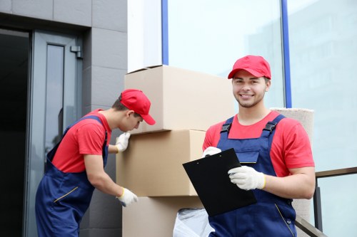 Professional furniture movers handling a sofa in Belgium
